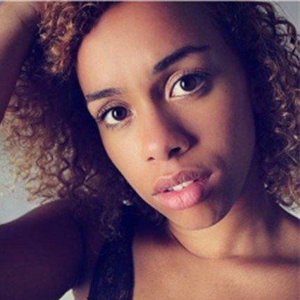 A close up of a woman 's face with curly hair