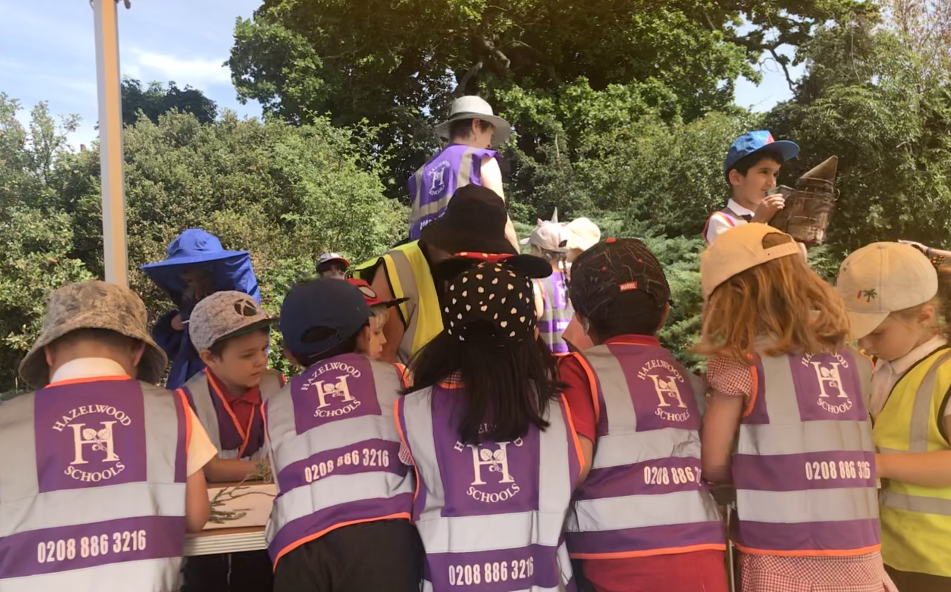 A group of children wearing safety vests with the letter m on them