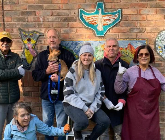 A group of people are posing for a picture in front of a brick wall.