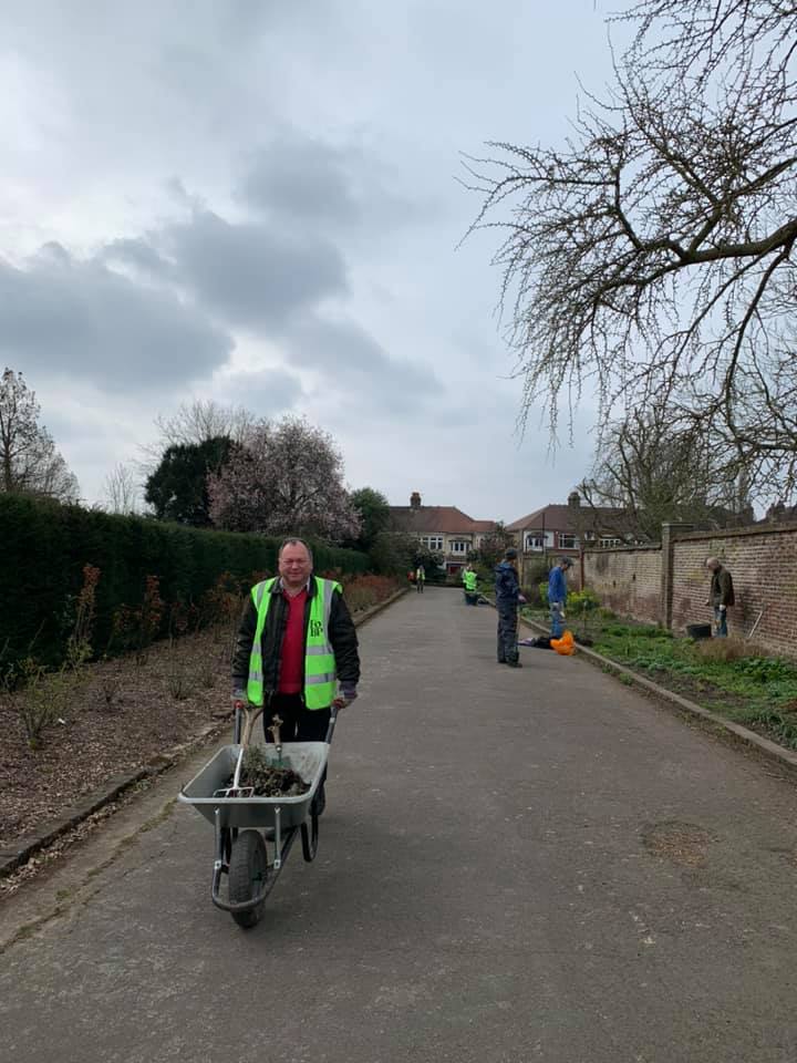 A man is pushing a wheelbarrow down a road.