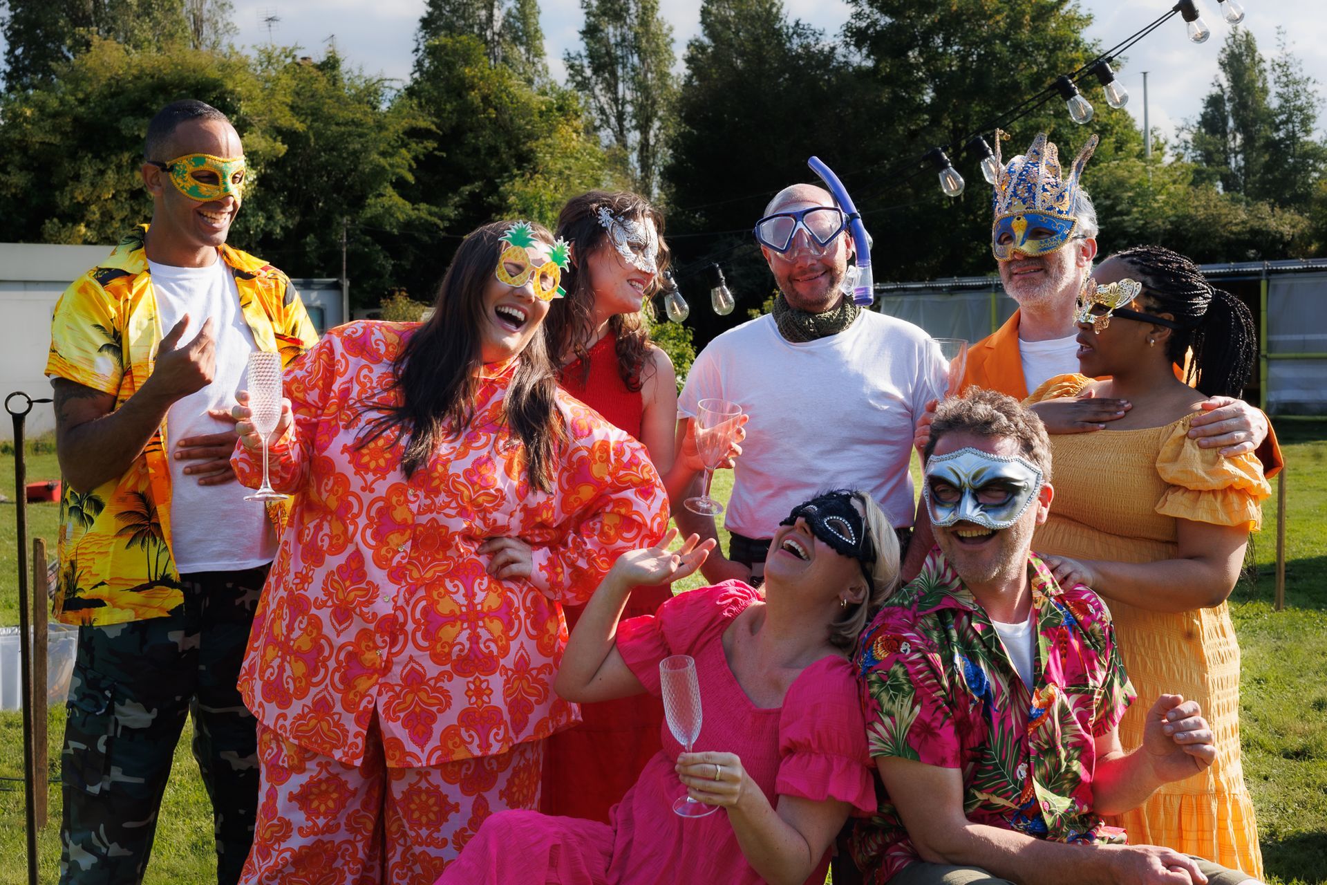 Group of people outdoors covered in bright colored powder, smiling and posing at a colorful celebration