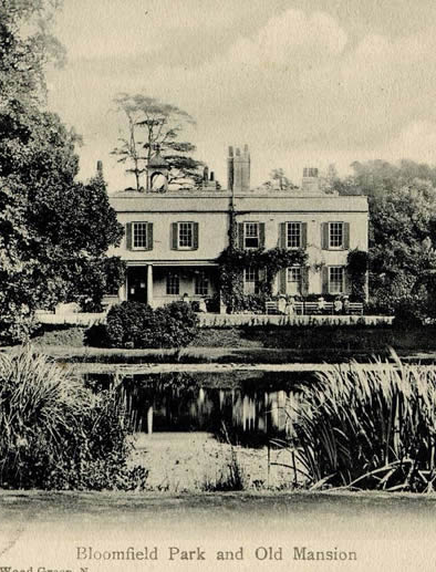 Historic manor house at Bloomfield Park, with trees, garden, and pond in foreground.