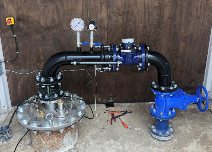 A blue valve is connected to a black pipe.