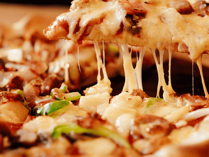 A close up of a pizza with cheese coming out of it