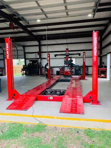 A red car lift is sitting inside of a garage.