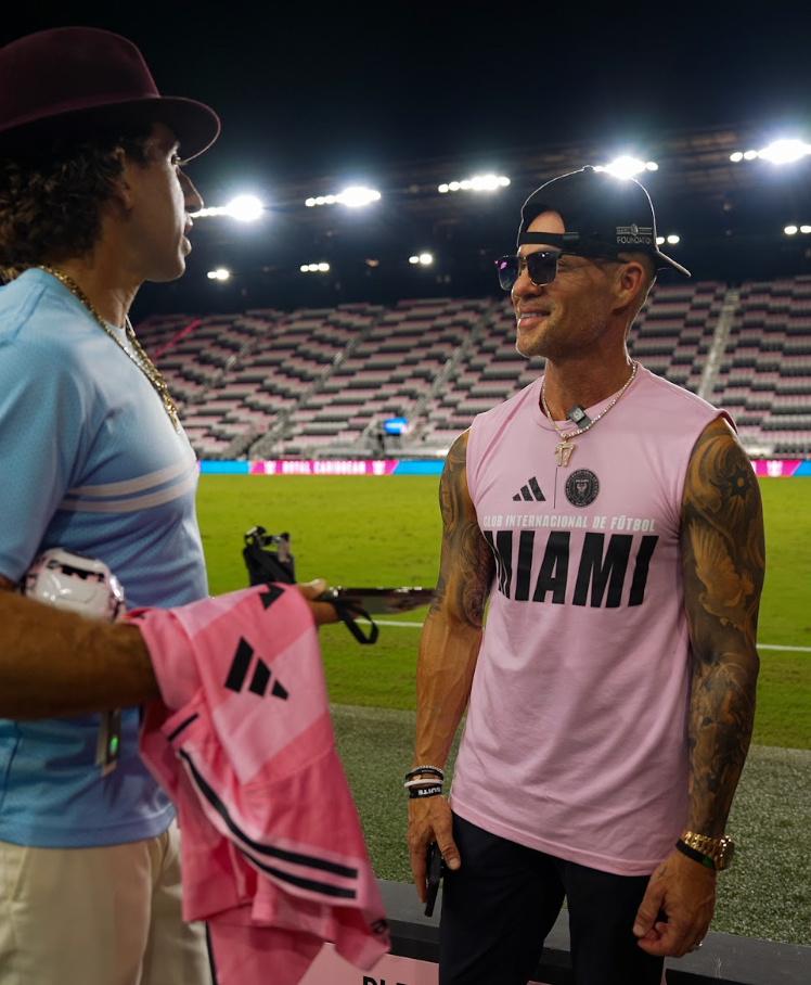 Marc Effron talking with a guest on a soccer field at night inside a stadium