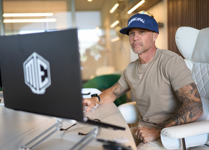 Marc Effron smiling while working at his desk with a phone and laptop