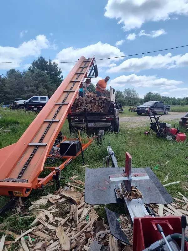  log splitter conveyor with workers loading firewood 2