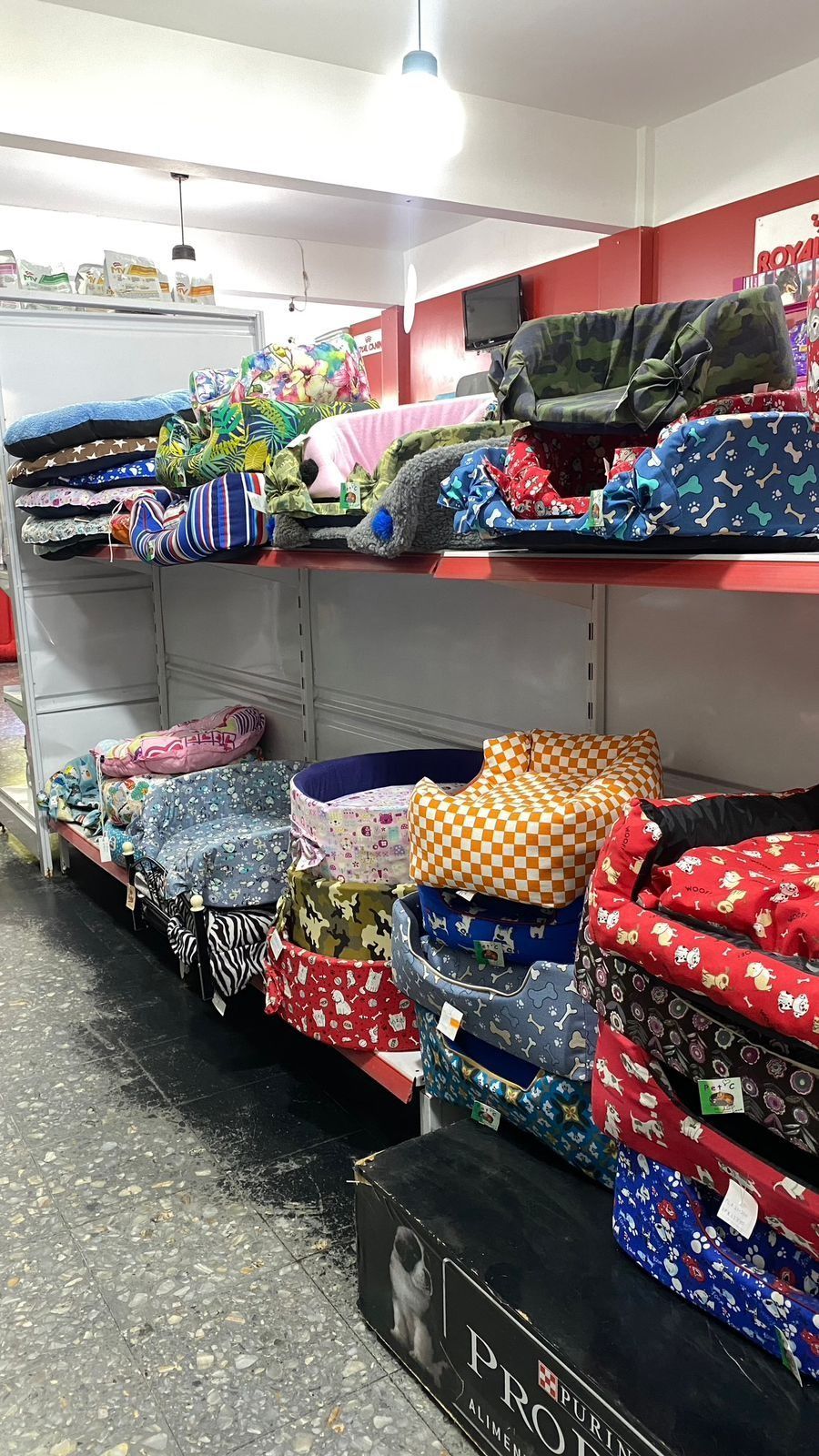Estanterías repletas de mantas y colchas coloridas dobladas en un pasillo de una tienda.