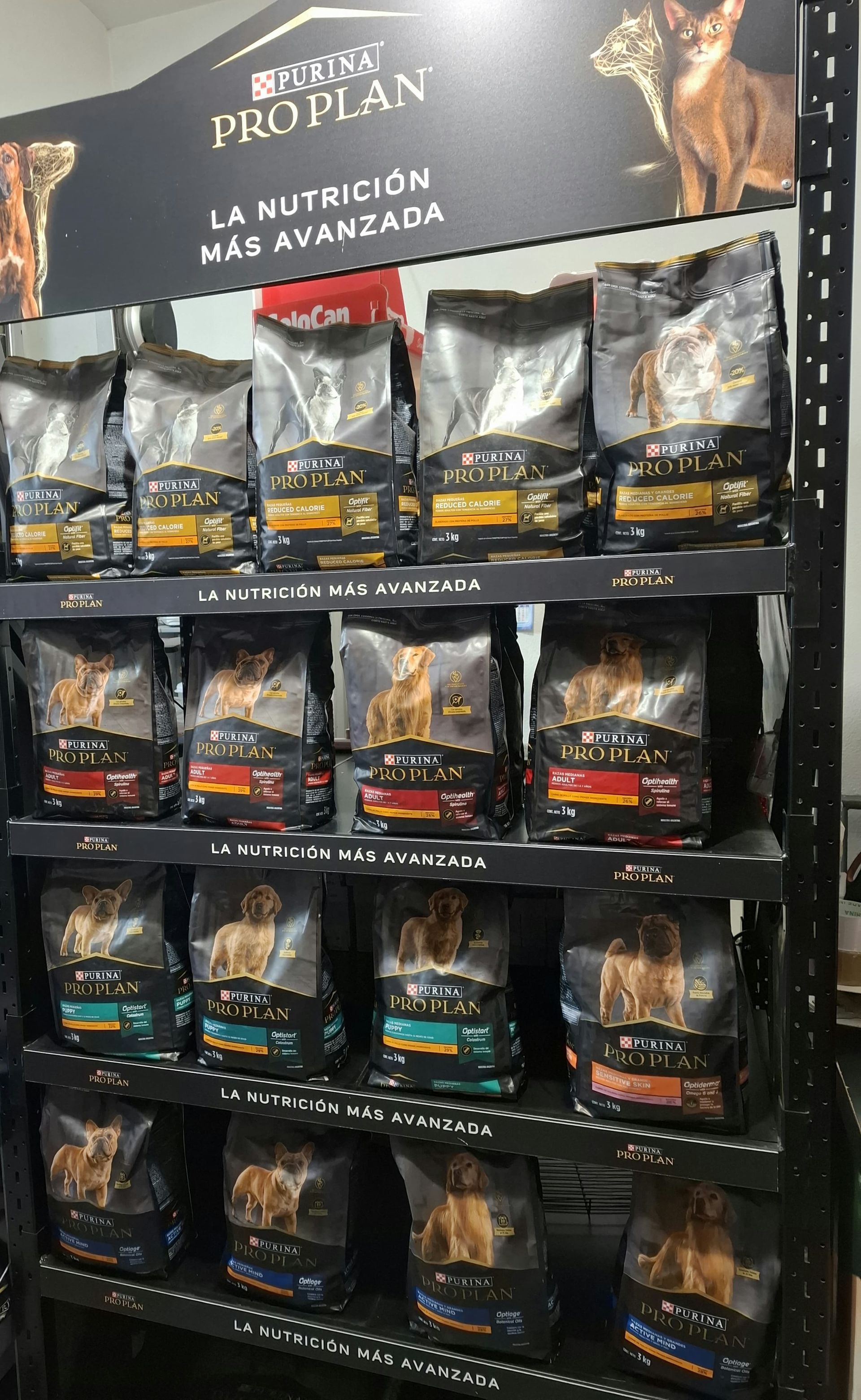 Retail dog food display with black packages and a sign reading “Pro Plan” and “La nutrición más avanzada.”
