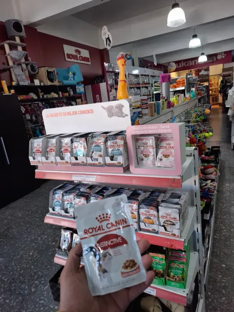 Exhibición en una tienda de mascotas: estanterías rosas con bolsas de comida para mascotas Royal Canin 