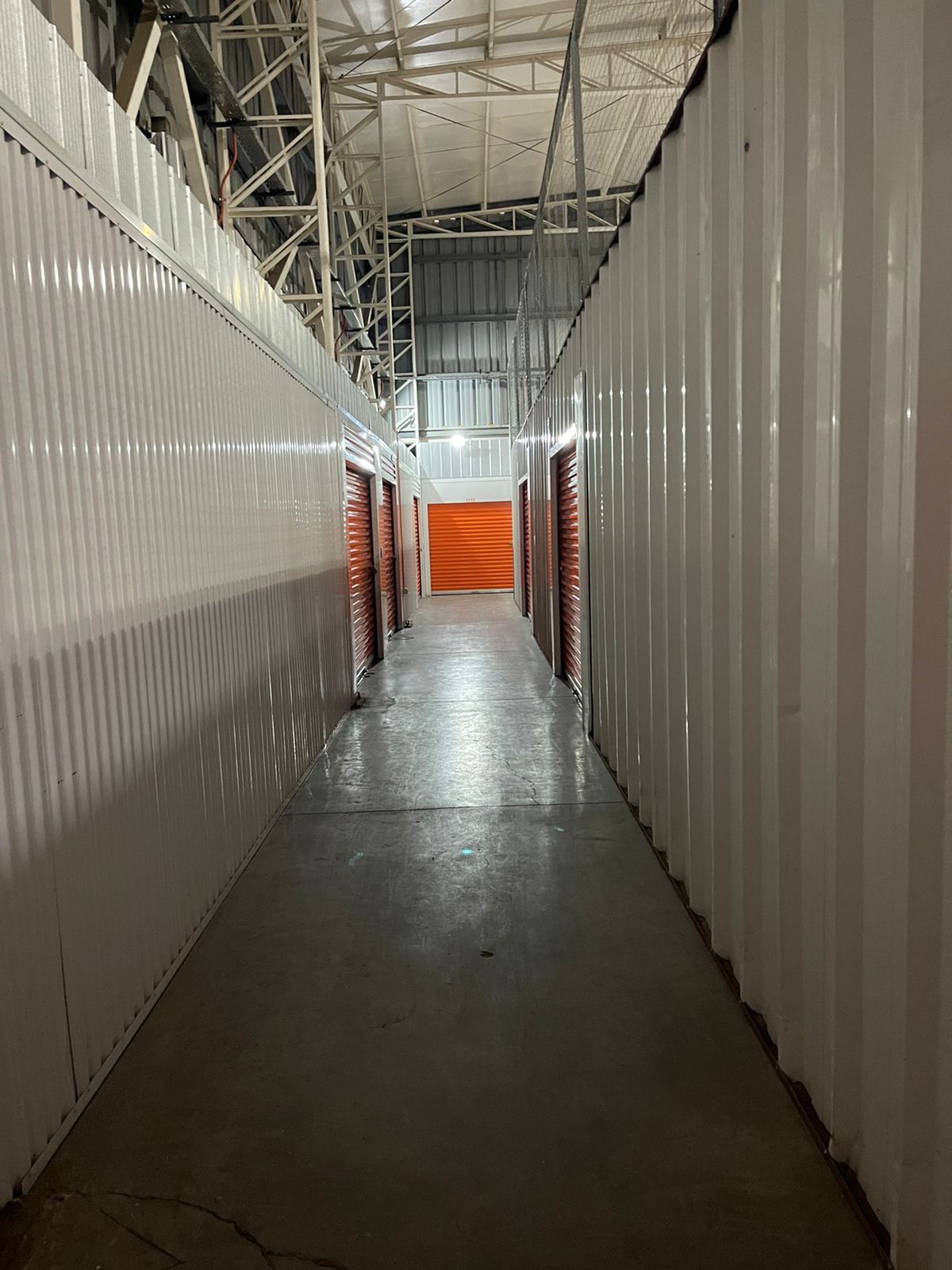 Entrada acristalada de un edificio de oficinas con puertas dobles, ventanas y una marquesina en la entrada.