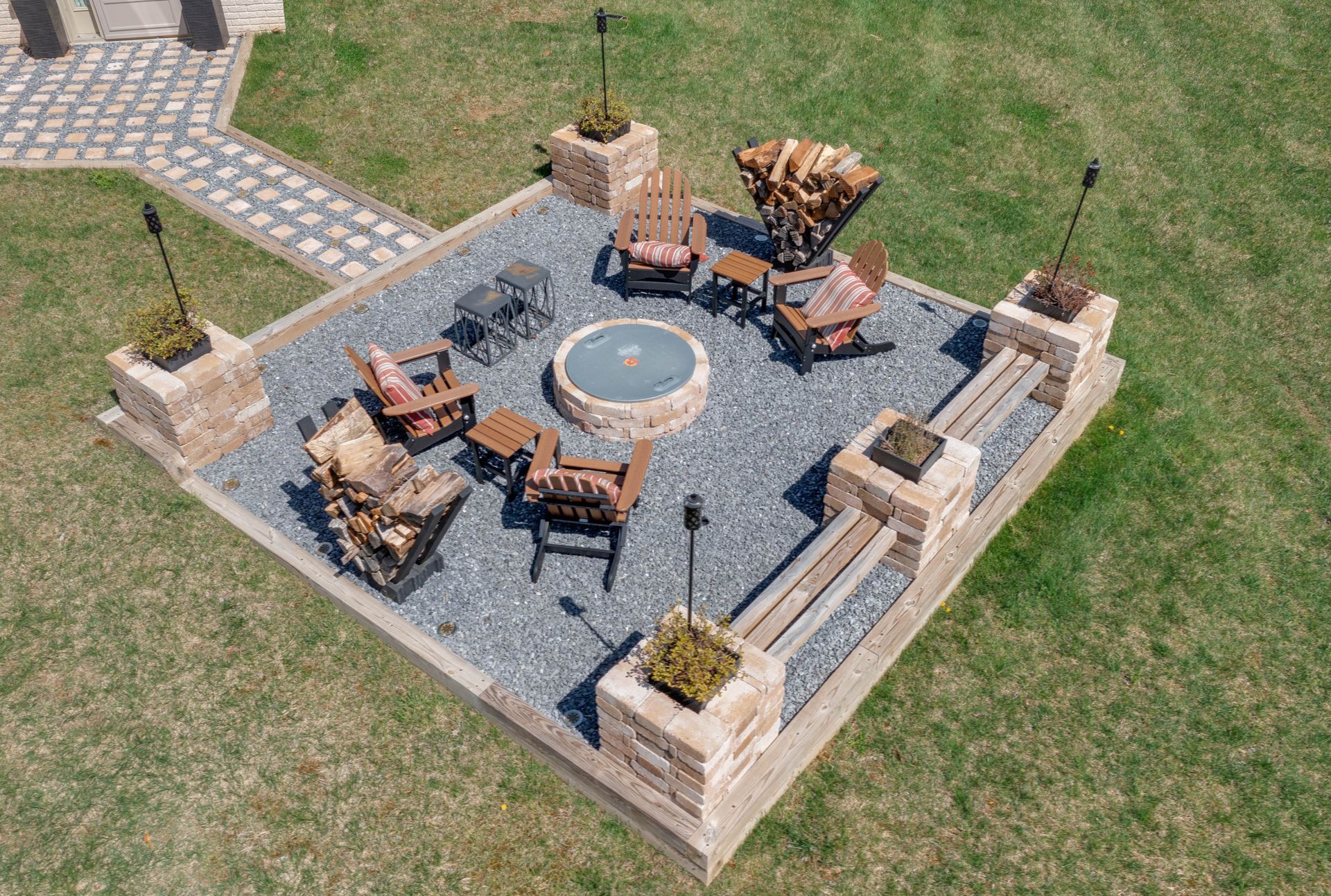 Outdoor hardscape fire pit area with stone seating and gravel flooring. Outdoor hardscape fire pit area with stone seating and gravel flooring.