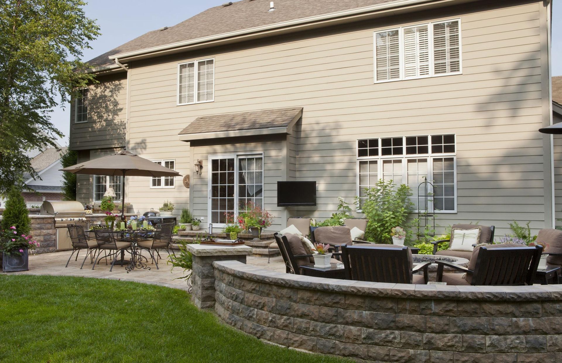 Backyard patio and hardscape in Buffalo Grove IL with seating wall, outdoor dining area, and professionally landscaped yard by Shelly’s Landscape Backyard patio and hardscape in Buffalo Grove IL with seating wall, outdoor dining area, and professionally landscaped yard by Shelly’s Landscape