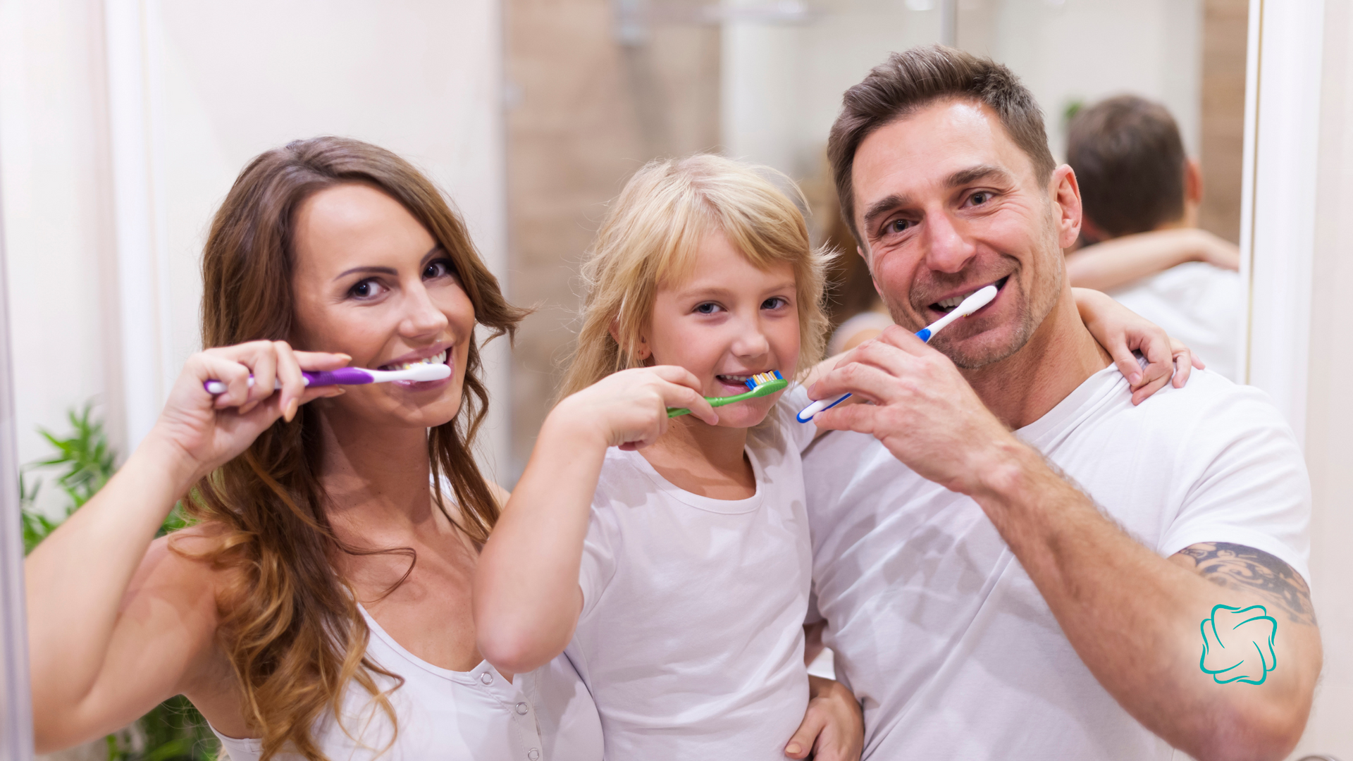 Family of three brushing their teeth together in a bathroom, smiling.