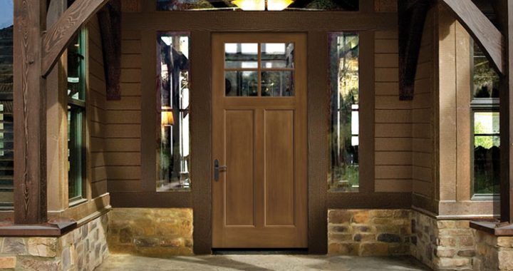 A wooden door is sitting in front of a stone building.