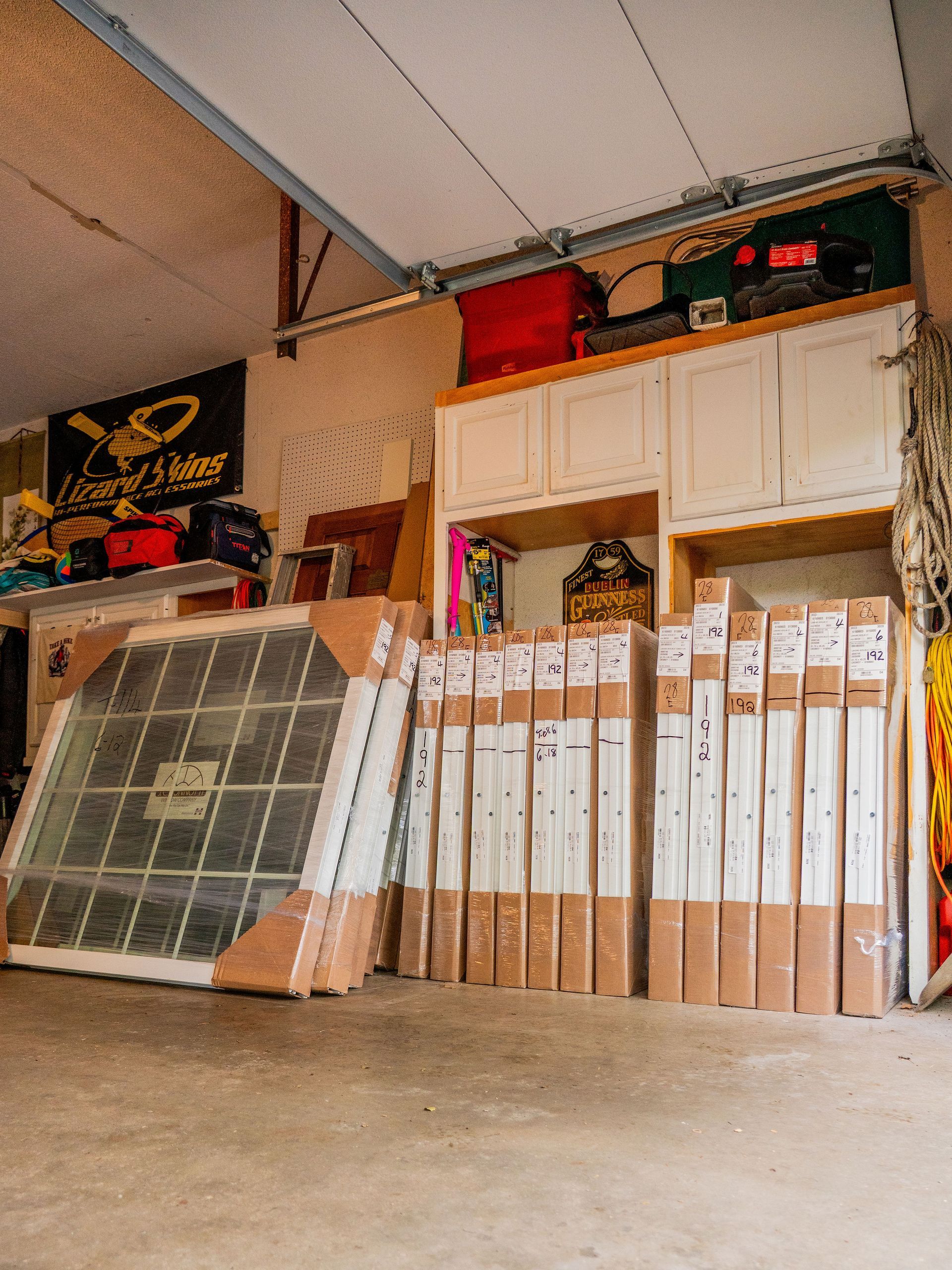 Garage interior with a large arched window and numerous packaged door frames.