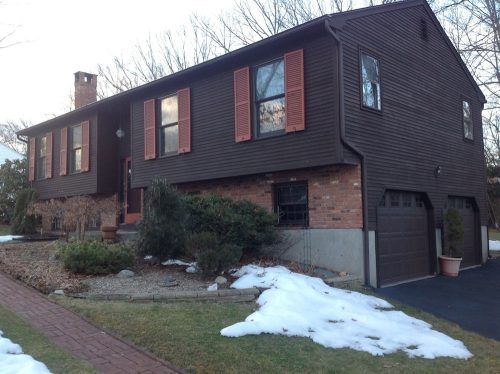 A brown house with red shutters and a garage