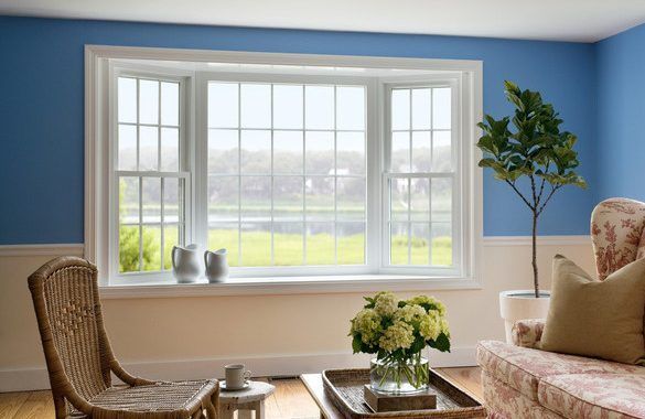 A living room with blue walls and a large window.