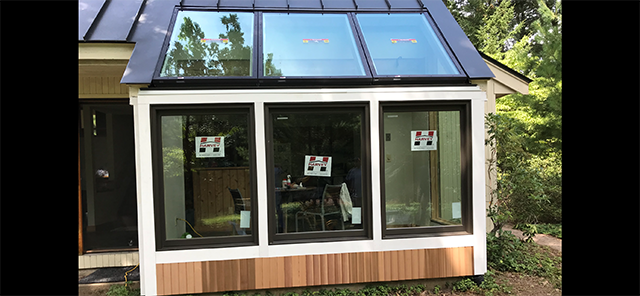 A sun and patio room with a lot of windows and a roof.