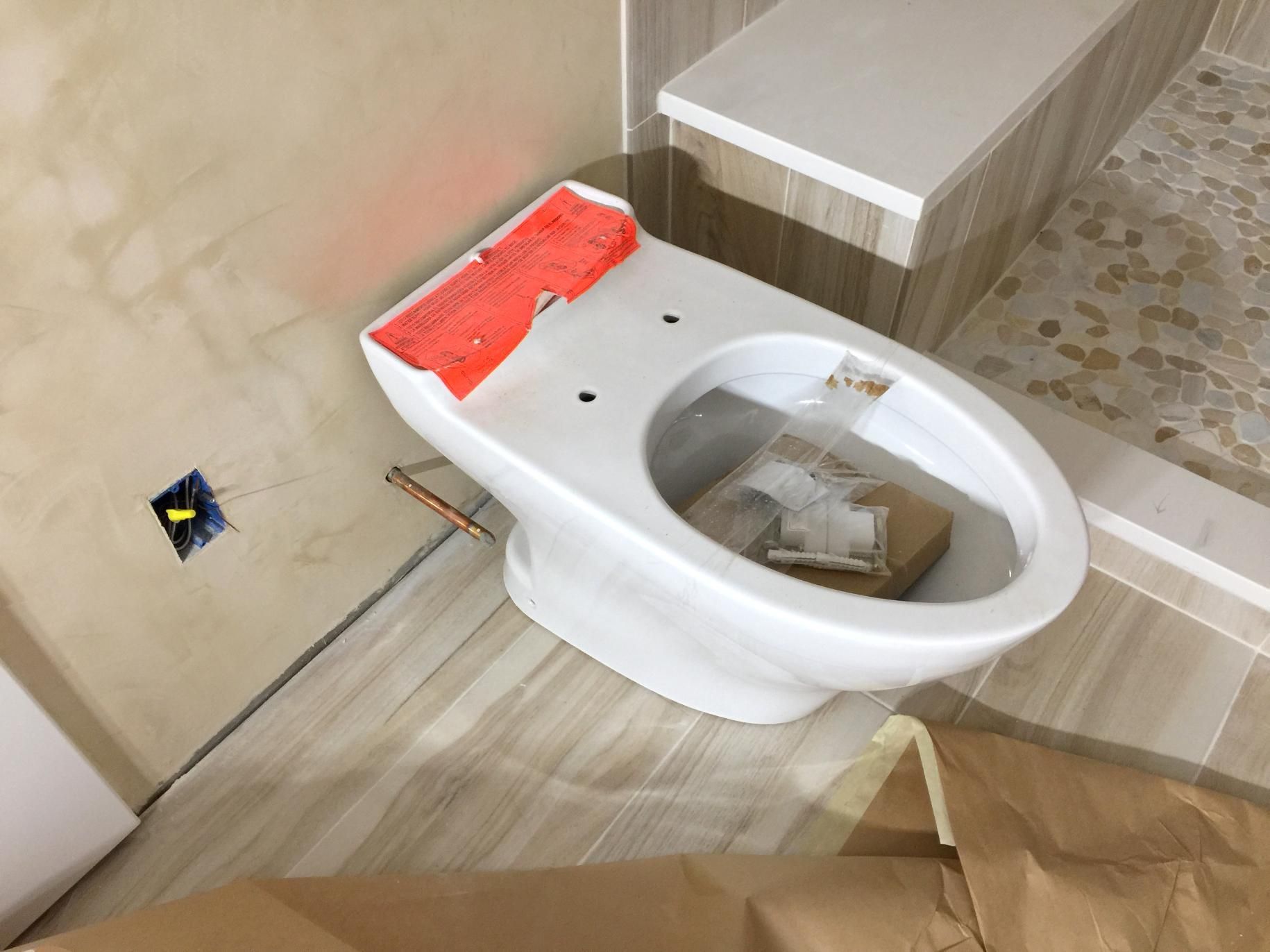 A White Toilet is Sitting in a Bathroom Under Construction — Subat Plumbing Services in Kurri Kurri, NSW