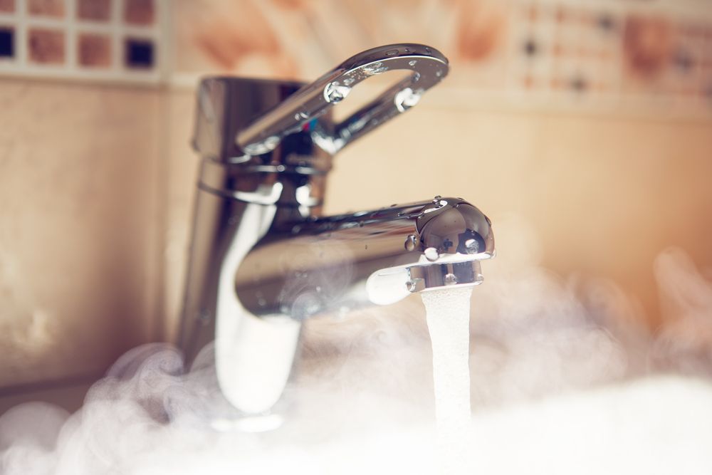 A close up of a faucet with steam coming out of it — Subat Plumbing Services in Cessnock, NSW