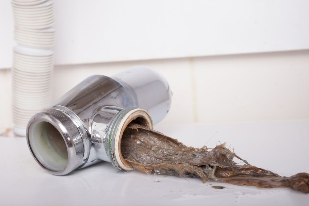 A Drain Pipe With a Lot of Dirty Water Coming Out of It — Subat Plumbing Services in Kurri Kurri, NSW