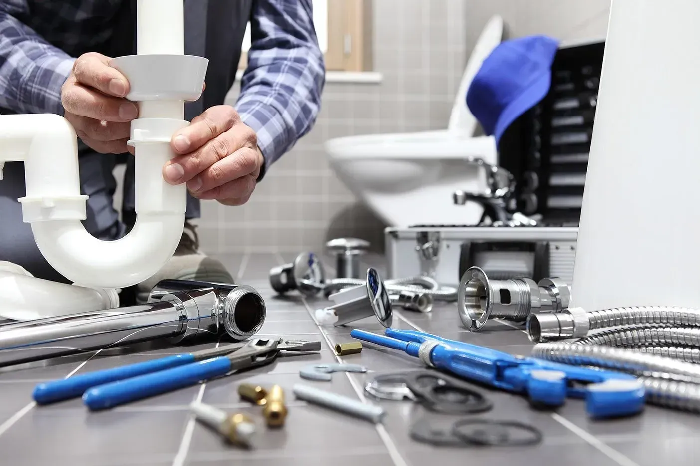 A Plumber is Fixing a Sink in a Bathroom — Subat Plumbing Services in Kurri Kurri, NSW