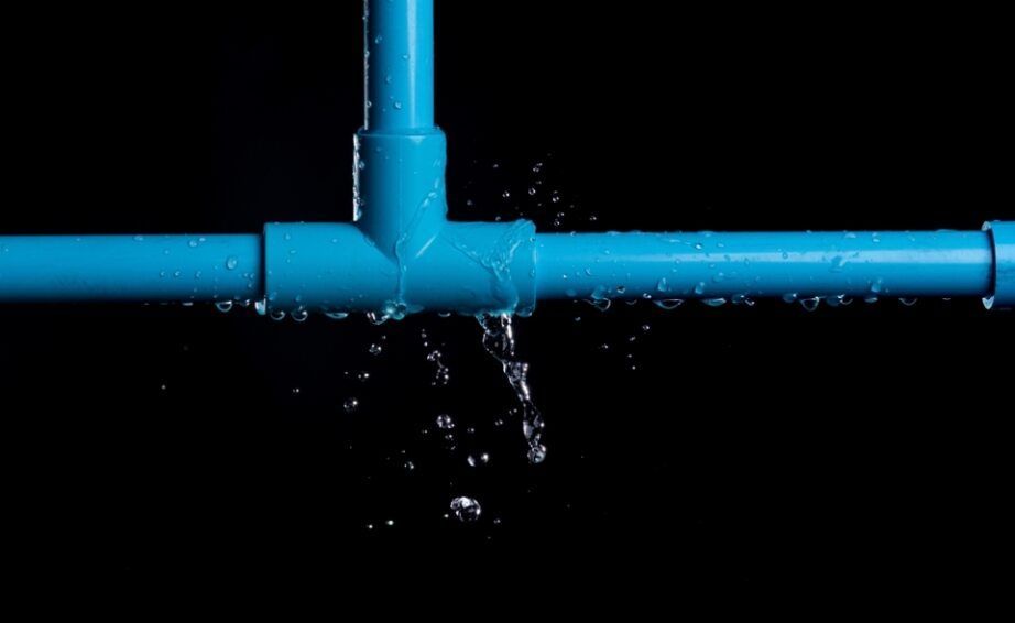 Water is Leaking From a Blue Pipe on a Black Background — Subat Plumbing Services in Kurri Kurri, NSW