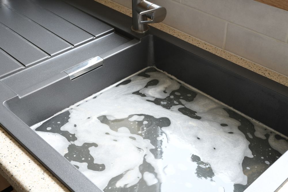 A Kitchen Sink With a Lot of Foam Coming Out of It — Subat Plumbing Services in Kurri Kurri, NSW