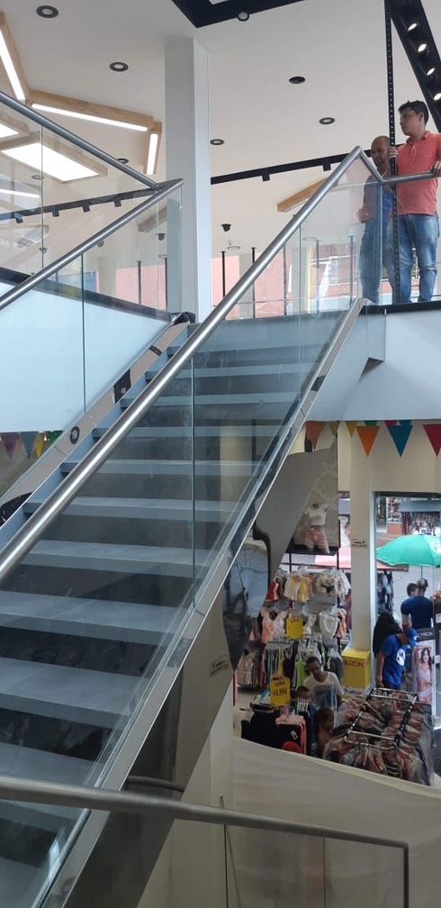 Escalera con barandilla de cristal en una tienda. 