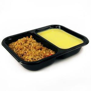 A two-compartment black plastic food tray, one side containing a golden brown crumble and the other a smooth yellow sauce.