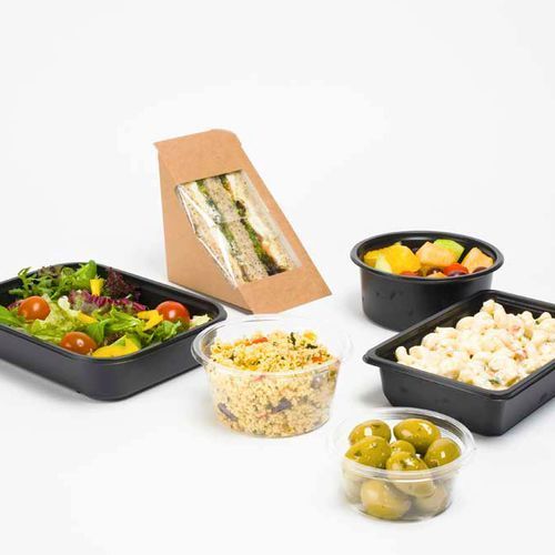 Assorted food items in takeout containers, including a sandwich, fresh salad, fruit, pasta, and olives on white background.