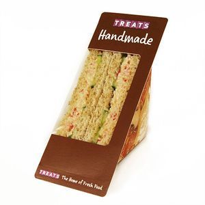 A triangular pre-packaged sandwich in brown cardboard branding labeled