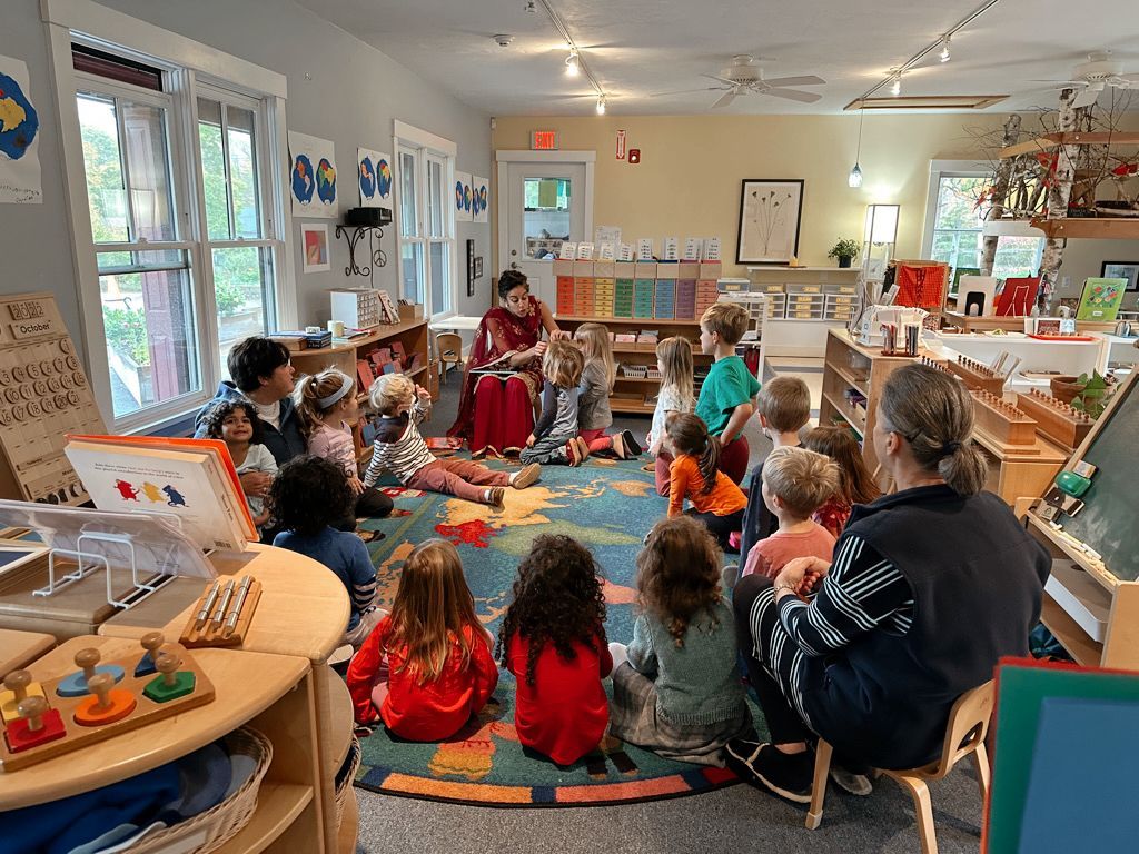 Montessori guide sitting in circle with kids in their classroom