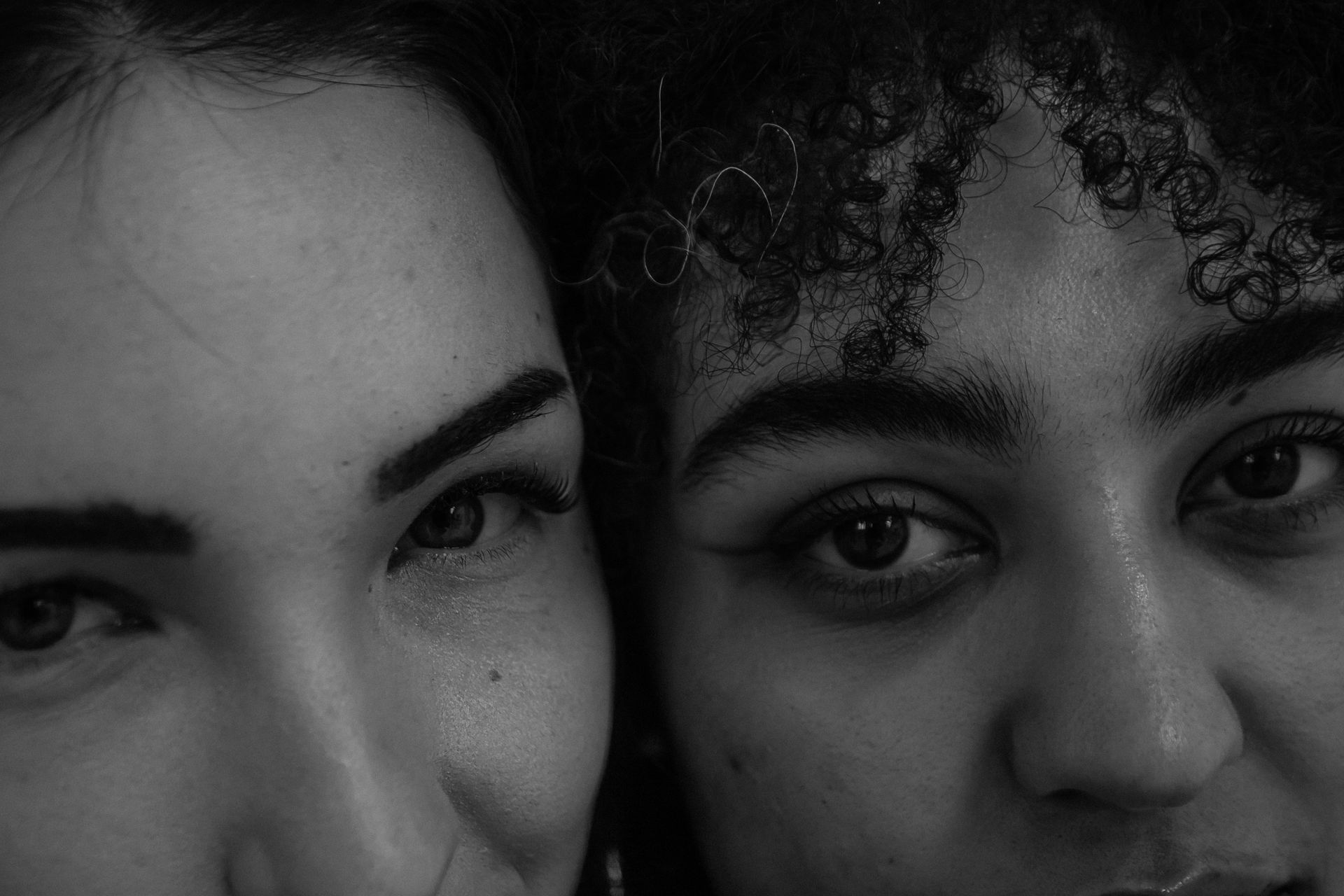 Two close-up faces in black and white, looking directly at the camera.