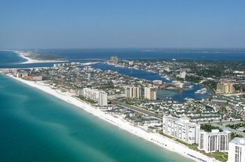 florida coastline An aerial view of a beach with buildings and a body of water.