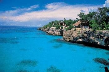 couples san souci A cliff overlooking a body of water with a house on it.