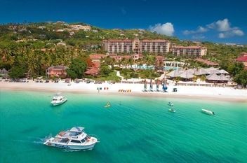 sandal grande antigua An aerial view of a beach with a boat in the water.