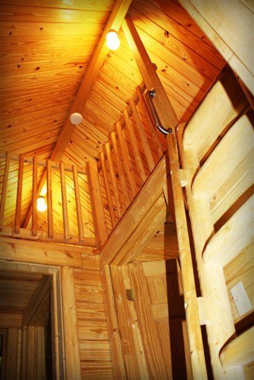 A wooden house with a staircase leading up to the second floor