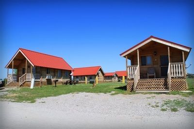 A group of cabins with red roofs are sitting next to each other.