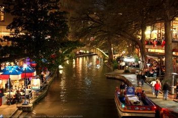 boat ride cruise A boat is floating down a river in a city at night