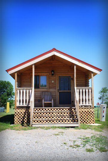 A small wooden cabin with a porch and stairs