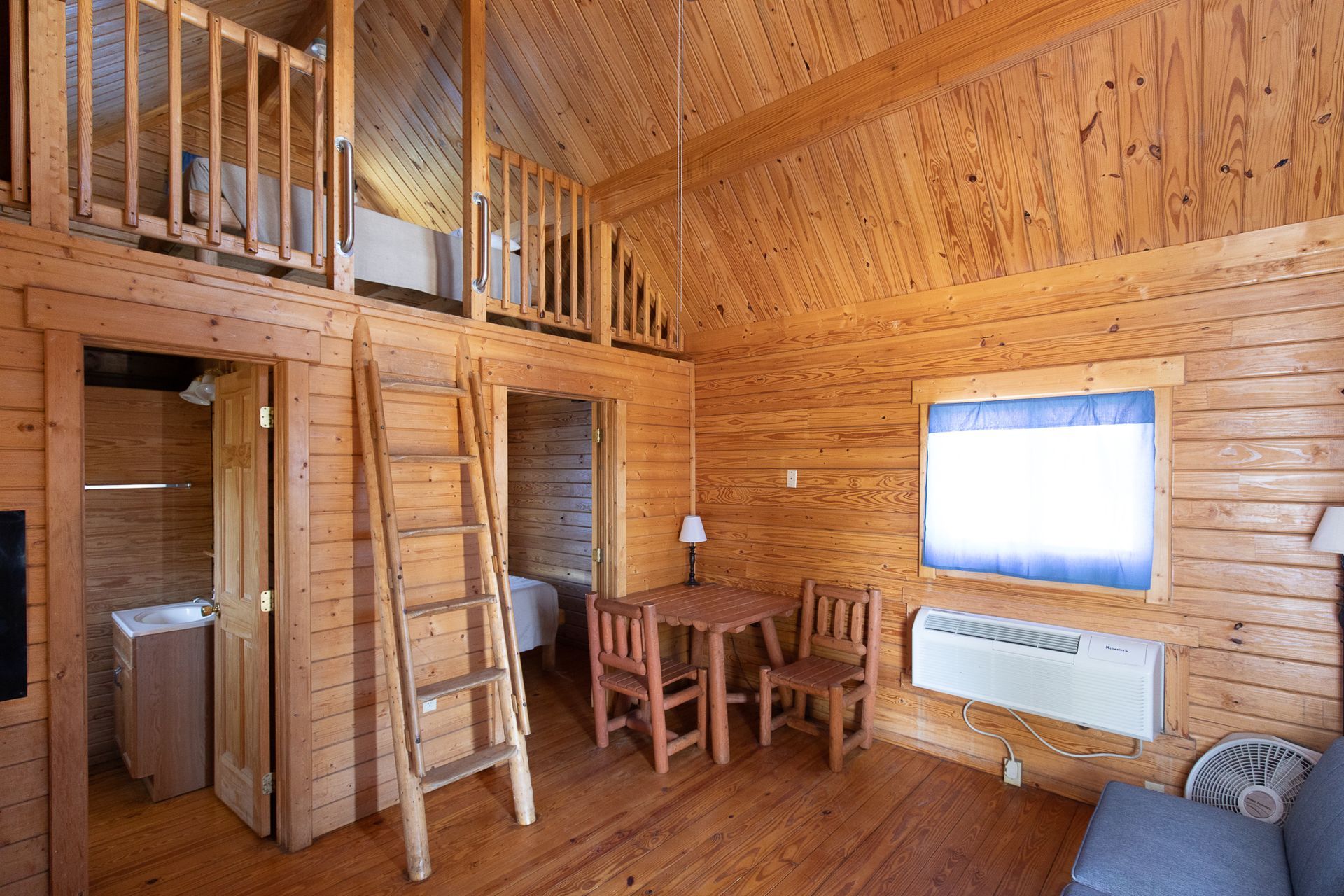 interior of log cabin LETRA cabin interior with a loft ladder, dining table and sleeping area.
