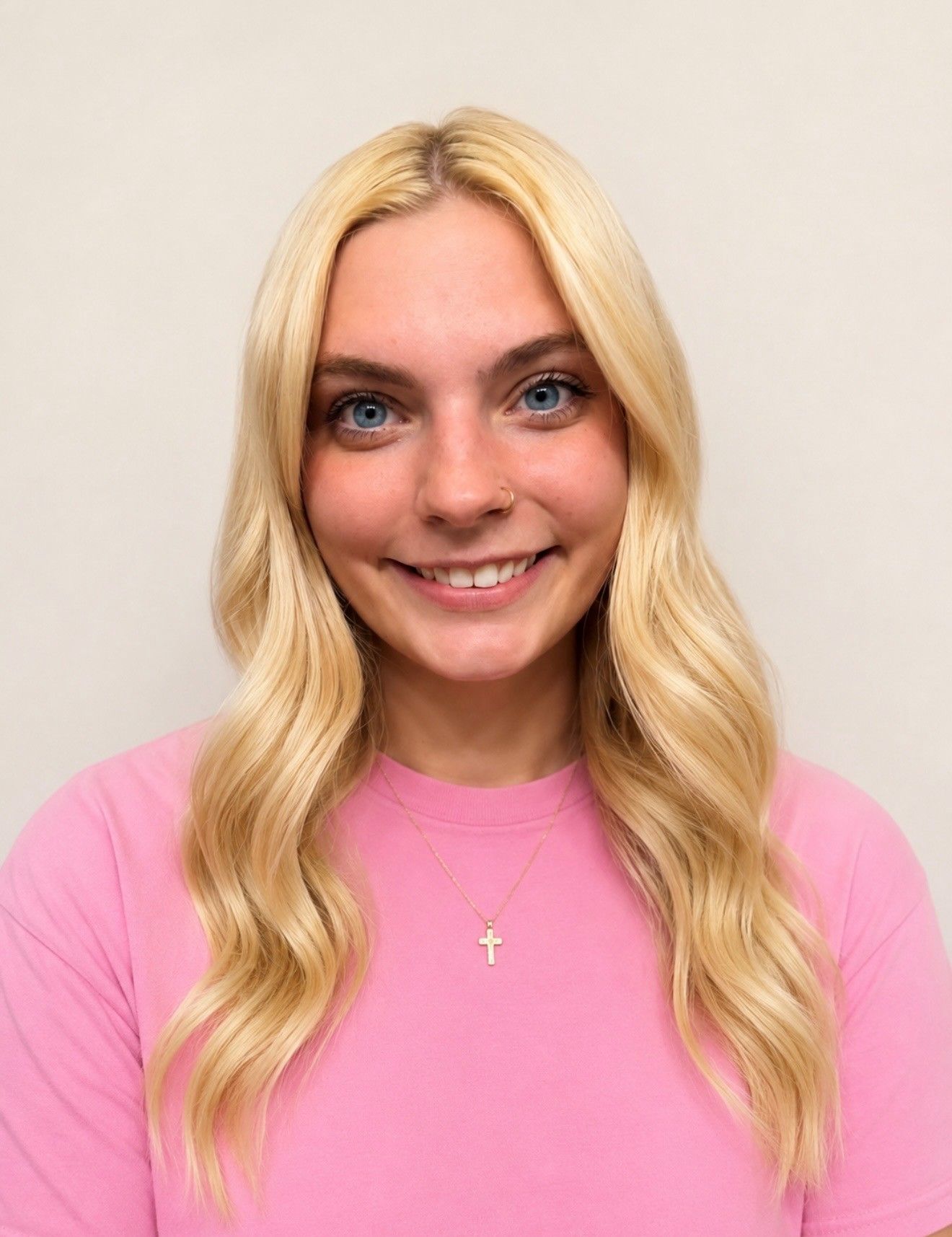 Blonde woman in a pink sweater A woman in a pink sweater is smiling for the camera.