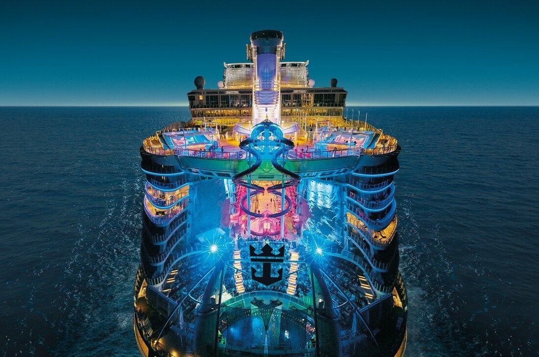 harmony of the ses A large cruise ship is floating on top of a body of water.