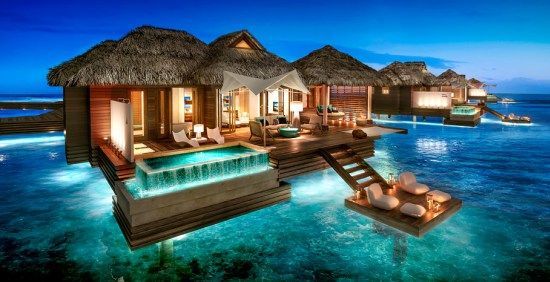 villa stilt house above water A house is floating in the middle of the ocean.