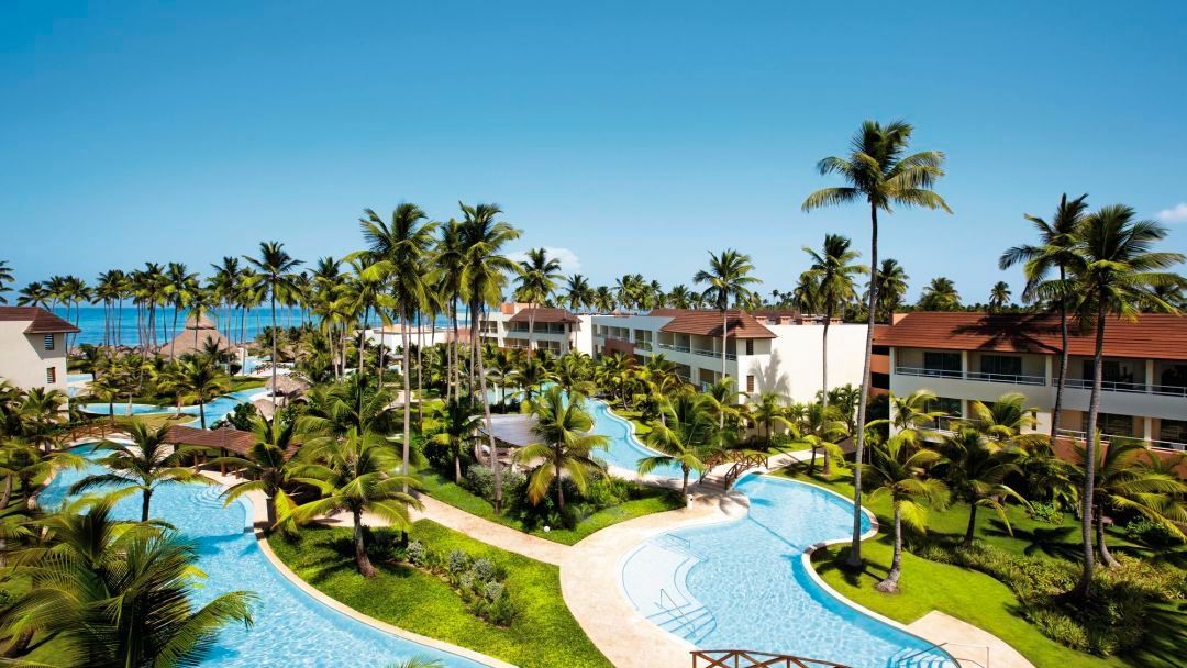 resort pools An aerial view of a tropical resort with a large swimming pool surrounded by palm trees.