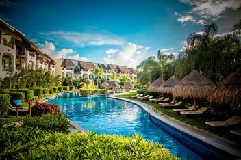 waterways through resort property A large swimming pool surrounded by chairs and umbrellas in a resort.