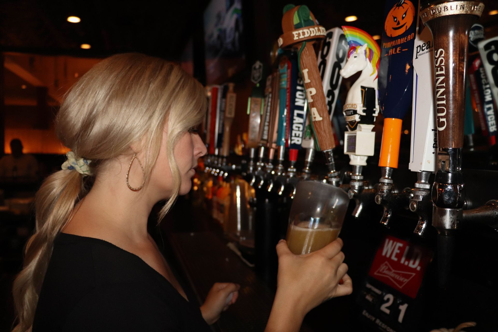 Bartender Pouring Pint in Front of Draft Beer Selection